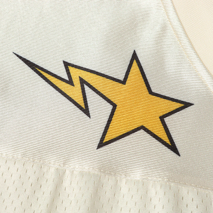 Close-up of a cream varsity football jersey with a yellow lightning star graphic and mesh streetwear fabric texture