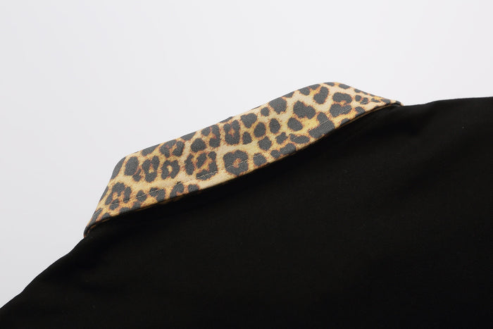 Black polo shirt with a leopard print collar, shown in a close-up on a clean white background
