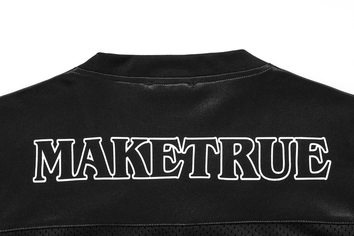 Black oversized mesh football jersey tee with gothic-style MAKETRUE graphic across the back neckline