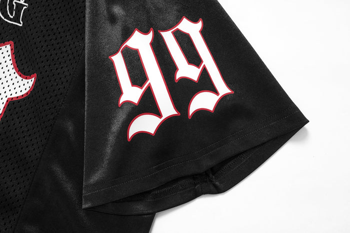 Black mesh football jersey sleeve with bold gothic white and red lettering on oversized streetwear top
