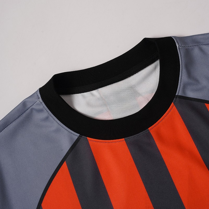 Close-up of a gray football jersey with black collar and bold orange vertical stripes on the front