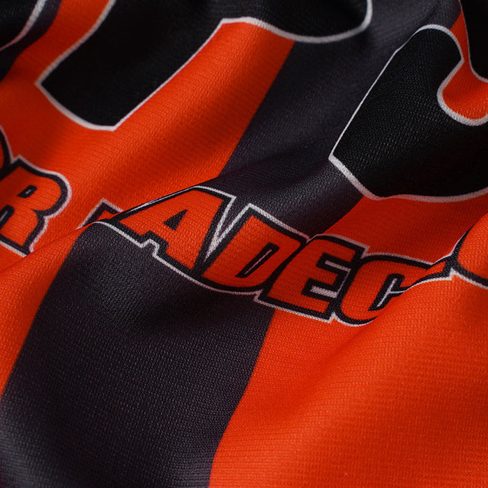 Close-up of orange and black vertical stripe football jersey fabric with bold printed lettering and number 69