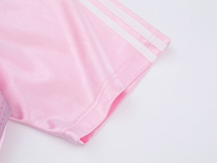 Light pink mesh soccer jersey sleeve with white stripes and stitched hem on a soft gradient tee