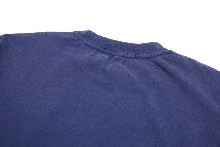 Upper back close-up of blue tee showing the crew neck seam and plain fabric