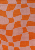 Patterned fabric with orange geometric shapes on a pink background