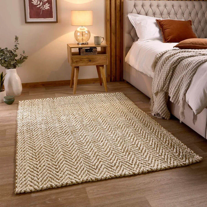 Bedroom with a patterned rug, bed, and side table.