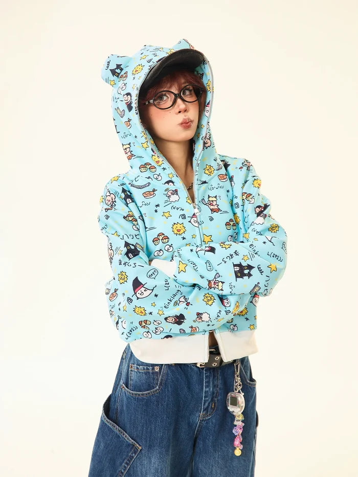Against a plain background, a person in Seakoff's Kawaii Cartoon Bear Hoodie—featuring cute ears and fun prints—exudes whimsical streetwear style. Completing the look with crossed arms, they pair it with loose-fitting jeans embellished with quirky accessories.