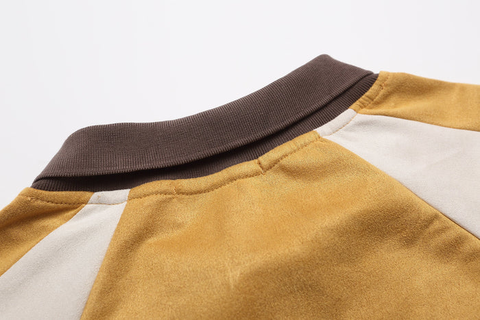 Close-up of the brown ribbed collar and shoulder seam on the mustard rugby top