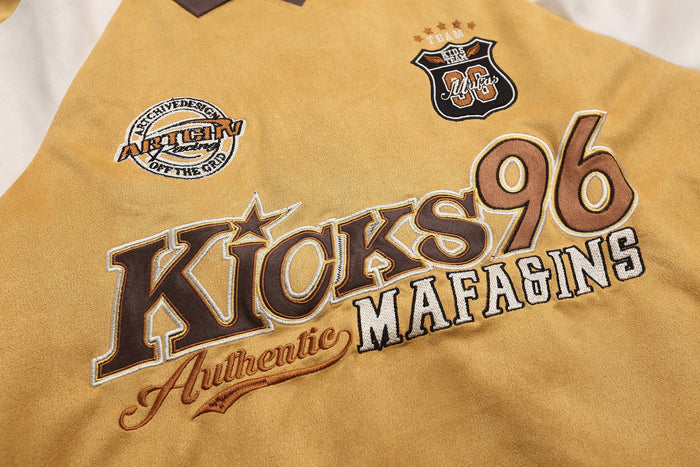 Close-up of embroidered front patches and Kicks 96 lettering on the mustard rugby top