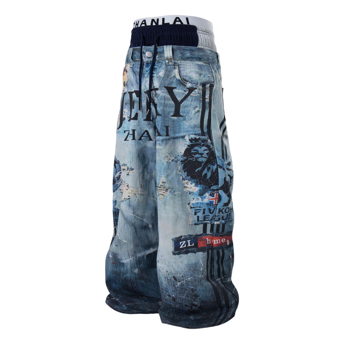 Front view of baggy blue denim pants with layered waistband and bold graphic print