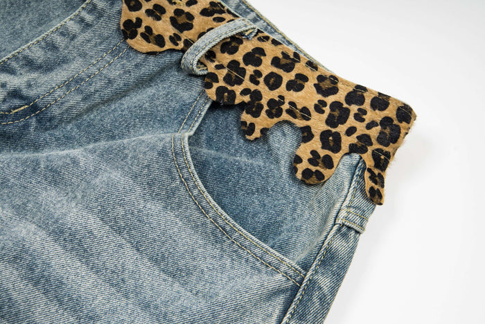 Side close-up of the leopard print waistband and curved back pocket on faded denim