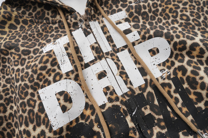 Front chest close-up of leopard print zip-up hoodie with white distressed lettering
