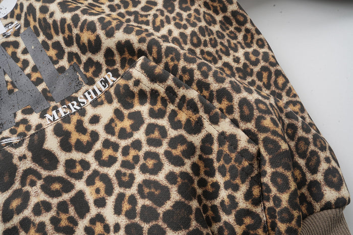 Upper chest and shoulder close-up of leopard print hoodie with side text detail
