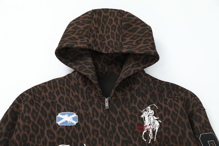 Front upper view of brown leopard print zip hoodie with hood, chest patches, and zipper
