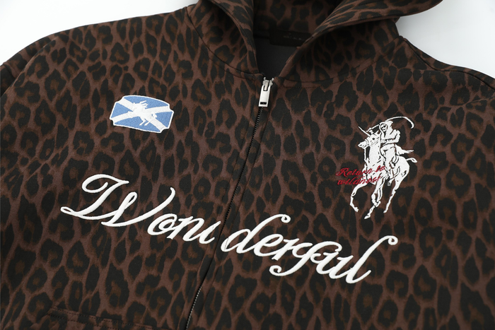 Front chest close-up of leopard print zip hoodie with "Wonderful" script and horse rider patch