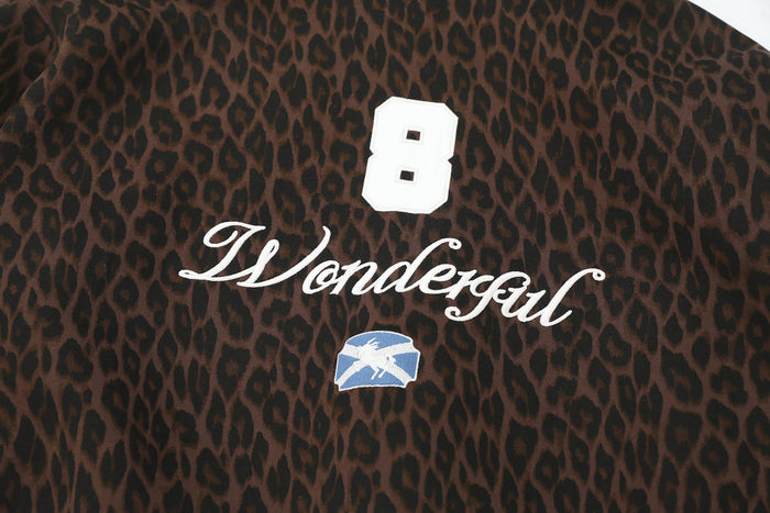 Chest close-up of brown leopard print hoodie with white "8" and "Wonderful" embroidery