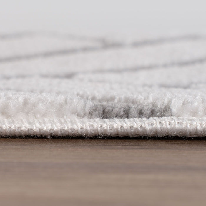Close-up of a textured gray rug on a wooden floor