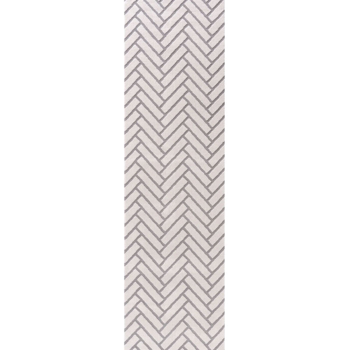 Rectangular area rug with a gray and white chevron pattern on a plain background