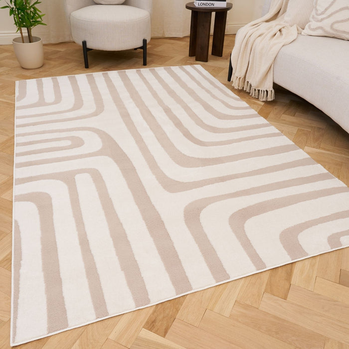 Beige and white patterned rug on a wooden floor with a sofa and chair in the background.