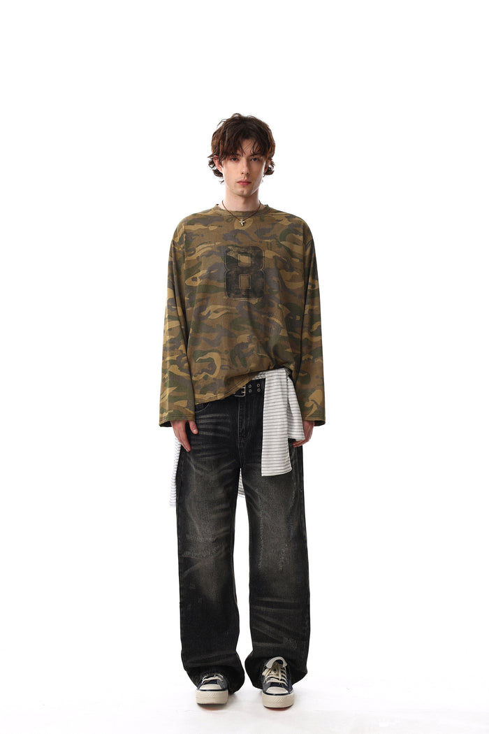 Full-length front view of model wearing camo long sleeve tee with faded number 8