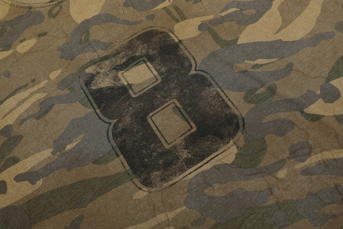 Close-up of distressed number 8 graphic on camouflage long sleeve tee