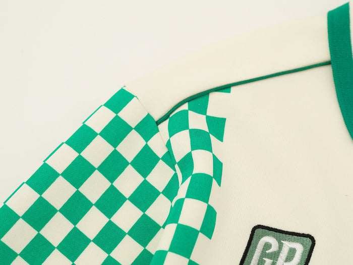Close-up of cream jersey shoulder seam and green checkered sleeve panel