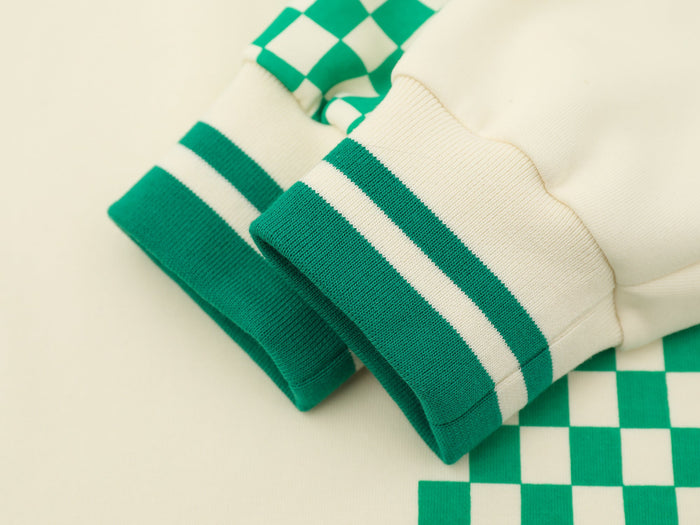 Close-up of cream cuff with green striped rib knit trim