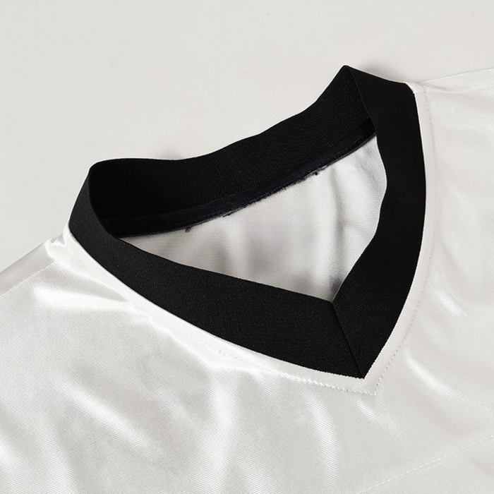Close-up of a white football jersey with a black V-neck collar and clean streetwear-inspired detailing