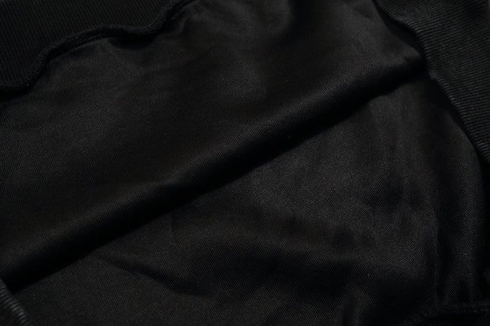 Close-up of black sweatshirt fabric texture with ribbed knit trim