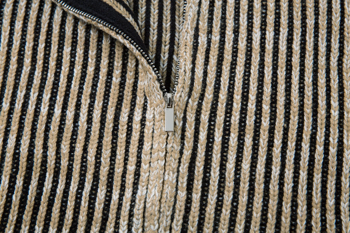 Close-up of the partially open front zipper on the striped ribbed knit jacket
