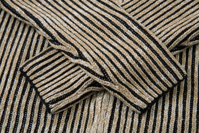 Close-up of the ribbed striped sleeve cuff on the knit jacket