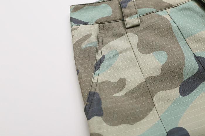 Close-up of camo shorts side seam and front pocket detail