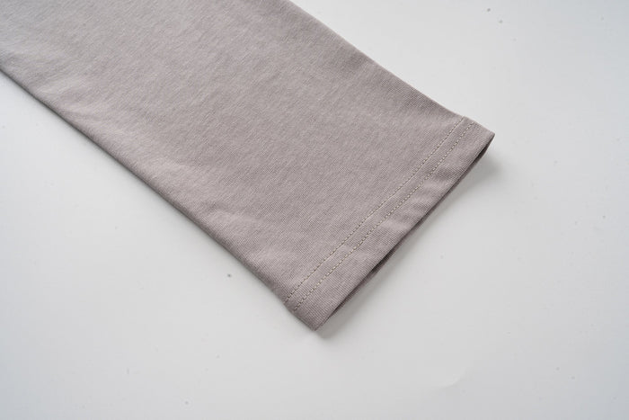 Gray long sleeve cuff close-up on layered camo tee