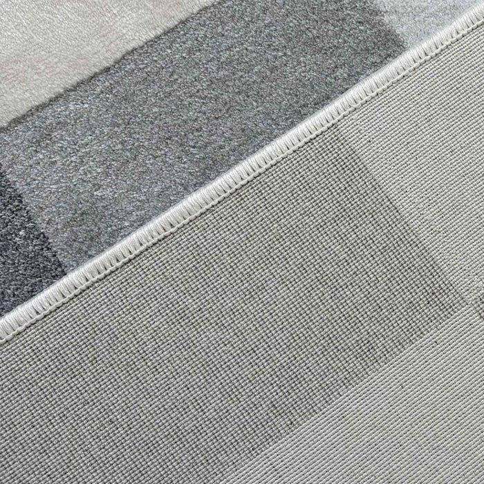 Close-up of a textured gray rug with a geometric pattern