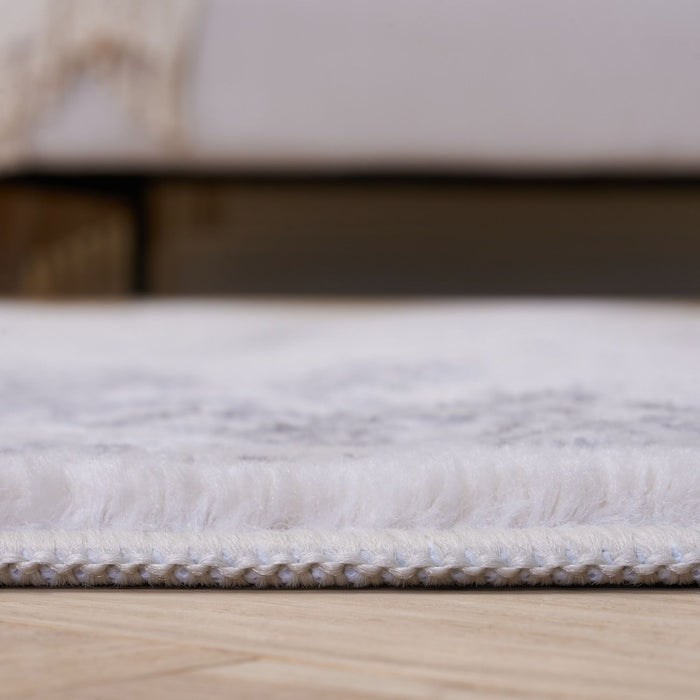 Close-up of a textured white rug on a wooden floor