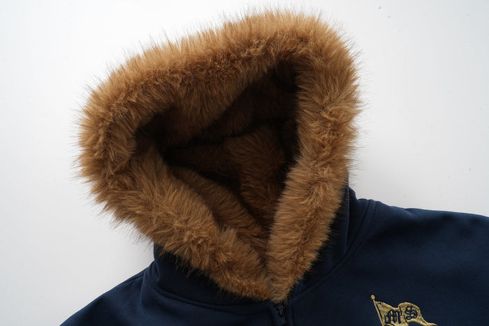 Close-up of navy hood lined with brown faux fur framing the hood opening