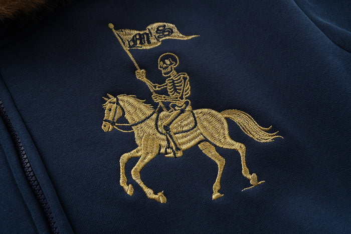 Close-up of gold horse rider embroidery on navy hoodie front