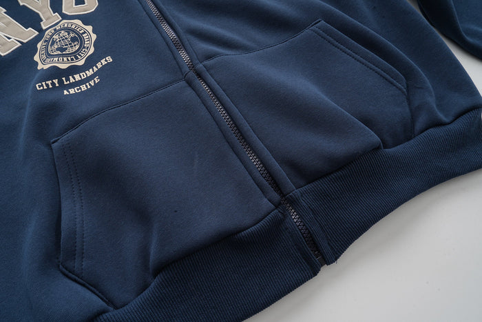 Front lower section of navy zip hoodie with kangaroo pockets and ribbed hem