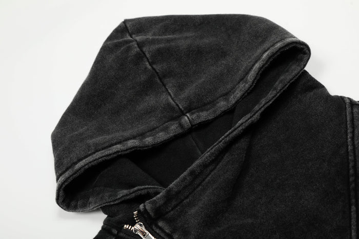 Close-up of black hooded jacket collar and asymmetrical zipper at the neckline