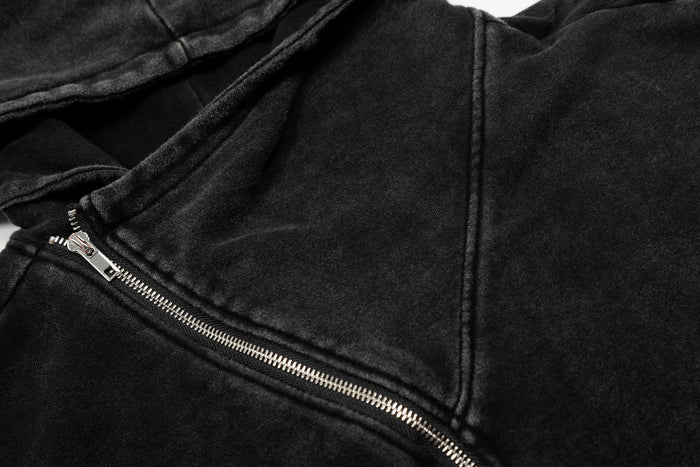 Close-up of black hoodie jacket chest seam and silver diagonal zipper