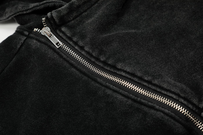 Close-up of black washed fabric with diagonal silver zipper teeth