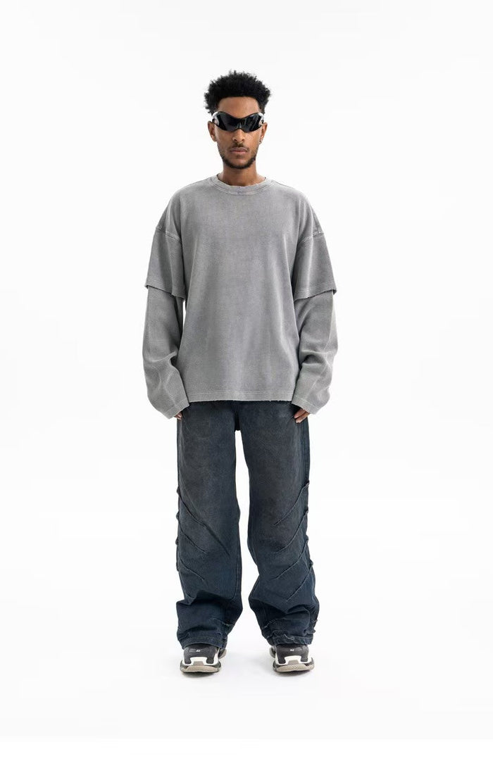 Gray oversized crewneck sweatshirt worn with wide sleeves and dark pants