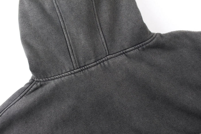 Close-up of the hood and shoulder seam on a dark gray washed cotton hoodie