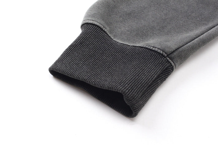 Close-up of a ribbed dark gray hoodie cuff with washed cotton texture