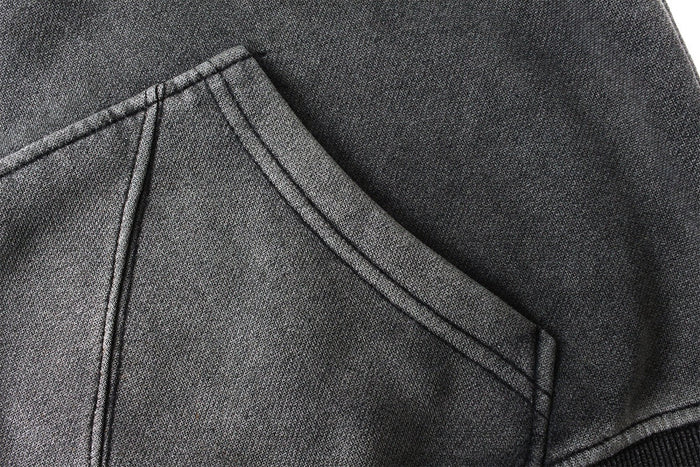 Close-up of a front chest panel and hood seam on a dark gray balaclava hoodie
