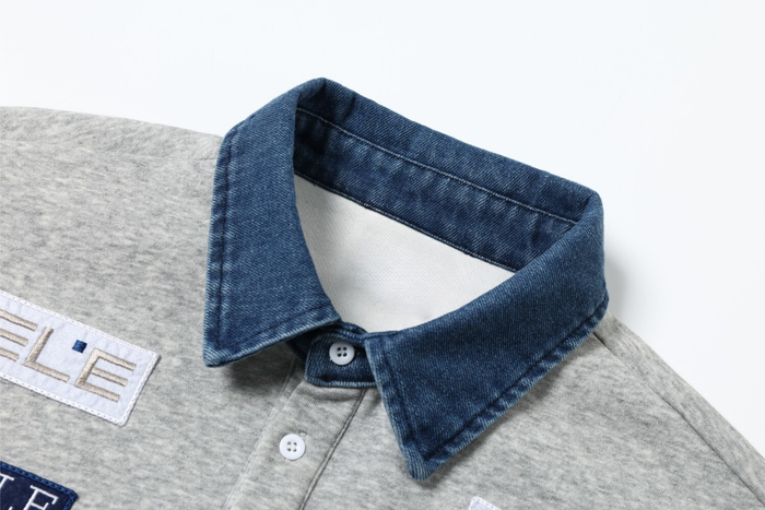 Close-up of denim polo collar with button placket on gray sweatshirt