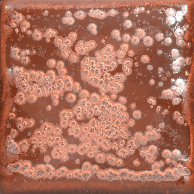 PC-56 Ancient Copper glaze test tile, glossy rust red with clusters of pale pink spots