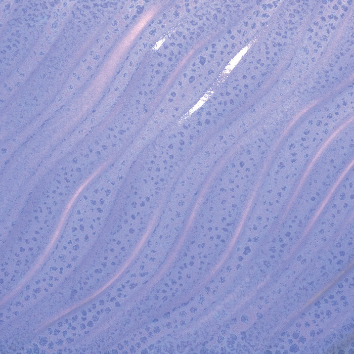 Close-up of Amaco PG-55 Floating Lavender glaze on a wavy ridged tile, glossy light purple with spotted texture