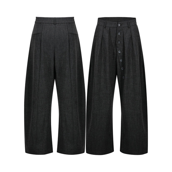 Dark charcoal wide-leg pleated pants with asymmetric button front closure, shown front and back view on white background