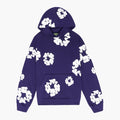 The Purple “Cotton Wreath” Denim Tears Hoodie is a streetwear pullover with a front pocket, featuring large white floral prints on purple fabric, inspired by the iconic Denim Tears style.